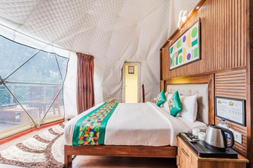 a bedroom with a bed and a large window at Treebo Wanderlust Residency With Mountain View in Munnar