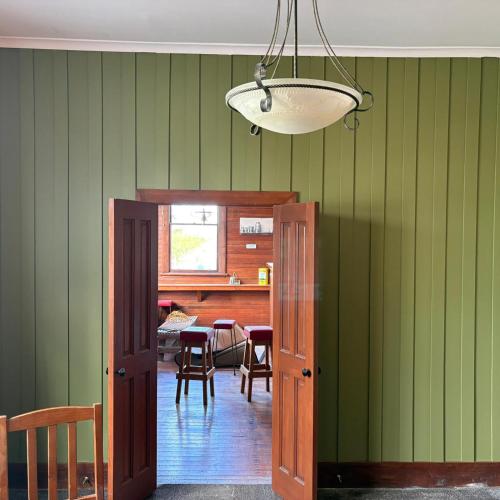 a room with green walls and a table with chairs at Central Otago Hydeaway in Hyde