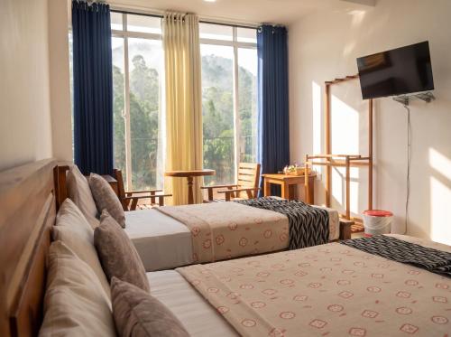 a hotel room with two beds and a window at Top Mountain Resort in Diyatalawa