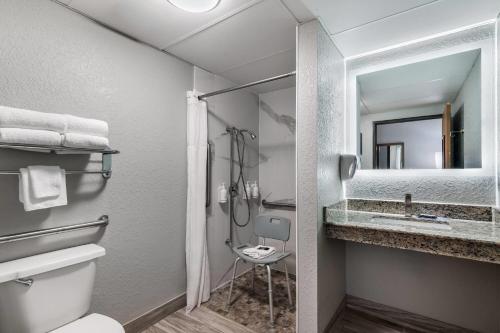 a bathroom with a toilet and a sink and a mirror at AmericInn by Wyndham Cloquet in Cloquet