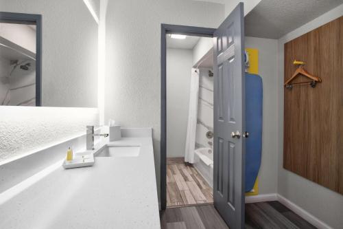 a room with a bathroom with a shower and a sink at Days Inn by Wyndham Gatesville in Gatesville