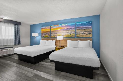a room with two beds and a painting on the wall at Days Inn by Wyndham Gatesville in Gatesville