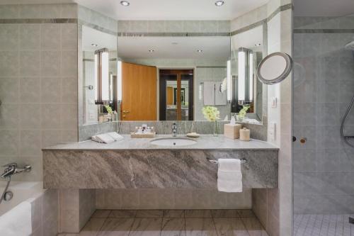 a bathroom with a large sink and a mirror at JW Marriott Bucharest Grand Hotel in Bucharest
