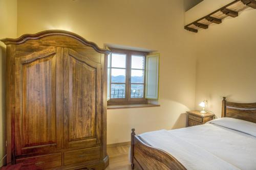 ファブリアーノにあるLa Castellaia Resortのベッドルーム1室(木製ベッド1台、窓付)