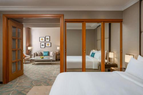 a bedroom with a bed and a living room at JW Marriott Bucharest Grand Hotel in Bucharest
