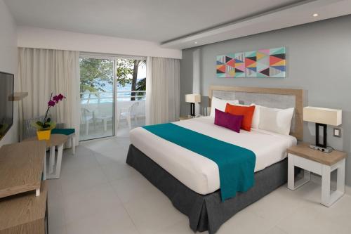 a bedroom with a large bed and a balcony at Casa Marina Sosua, Trademark by Wyndham All Inclusive in Sosúa