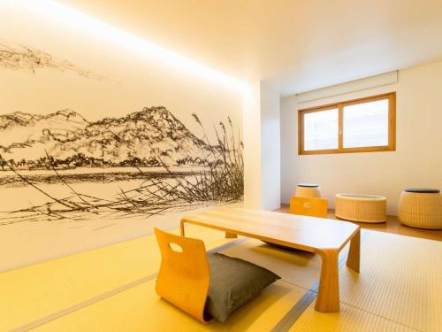 a living room with a bench and a painting on the wall at TSUCHIYA Kinosaki onsen in Toyooka