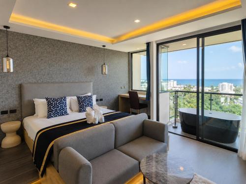 a bedroom with a bed and a couch and a tub at Karon Utopia in Karon Beach