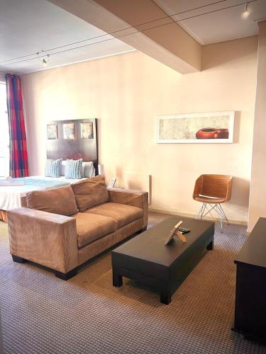 a living room with a couch and a bed at iNtsika Boutique in Johannesburg