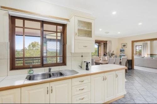 a kitchen with a sink and a large window at Twilight Ridge in Bega