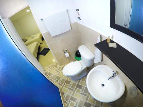 a bathroom with a white toilet and a sink at Hotel Molino de Viento in San Andrés