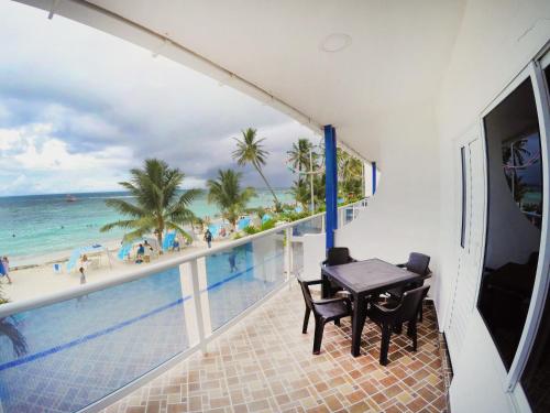 balcón con mesa y vistas a la playa en Hotel Molino de Viento, en San Andrés