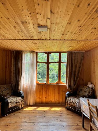 a room with two beds and a large window at In the Forest in K'vemo Jocho