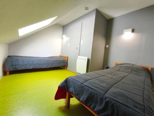a room with two beds and a yellow floor at Gite la Borie de Pourtou Santoire in Condat