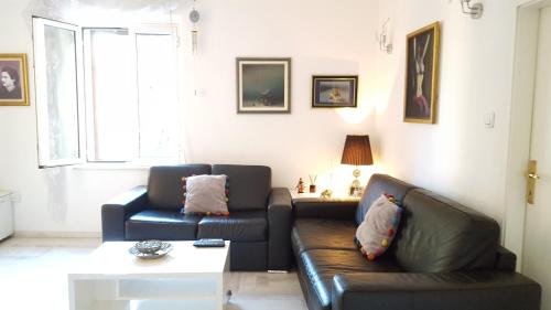 a living room with two leather couches and a table at Apartment Kiki in Kotor