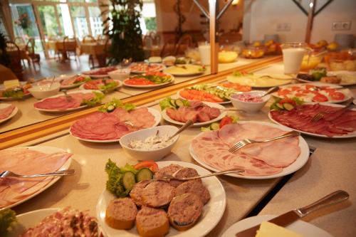 a buffet with many plates of food on a table at Flairhotel Hubertus in Bad Zwischenahn