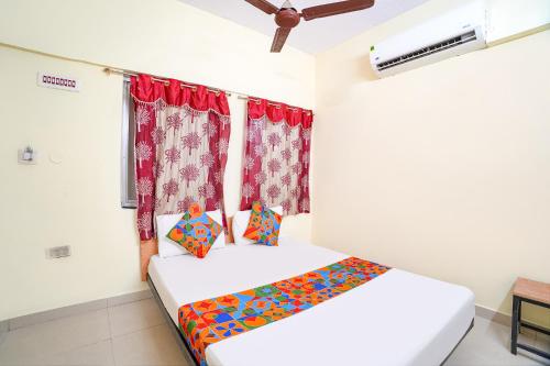 a bedroom with a bed and a window at FabHotel Mara Residency in Chennai
