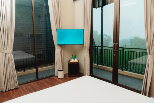 a room with a bed and a tv on a balcony at Acasa Cottage by Samsara in Cipaok