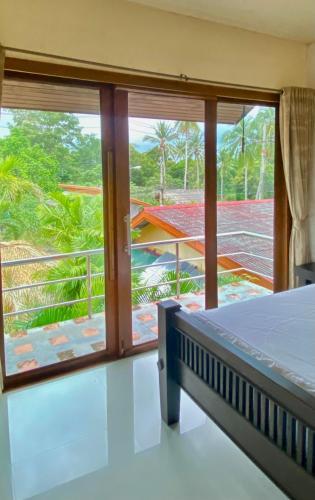 a bedroom with a bed and a view of a balcony at TNP place in Thong Nai Pan Yai