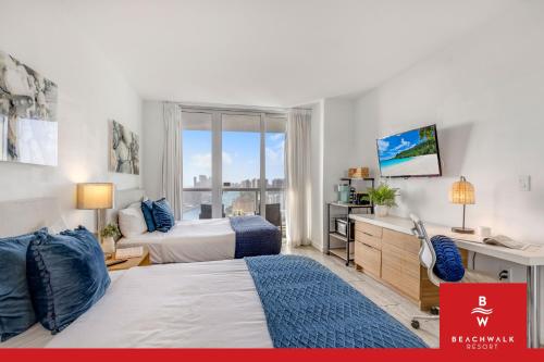 a bedroom with two beds and a desk and a window at New High-Floor Studio Bay & Private Balcony in Hallandale Beach