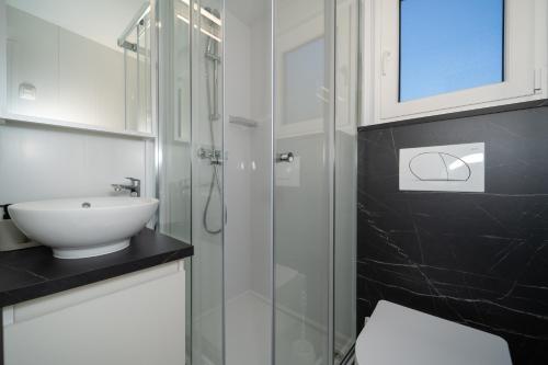 a bathroom with a glass shower and a sink at Camping Nevia - Mobile Homes with Heated Private Pool in Neviđane
