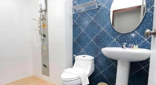 a bathroom with a toilet and a sink and a mirror at Soontree House Hotel in Udon Thani