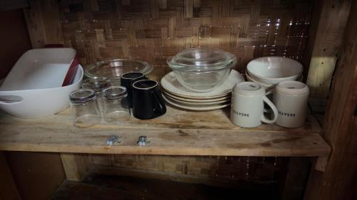 a shelf with a bunch of dishes and cups on it at Ghxabara Cozy Cabin in Maun