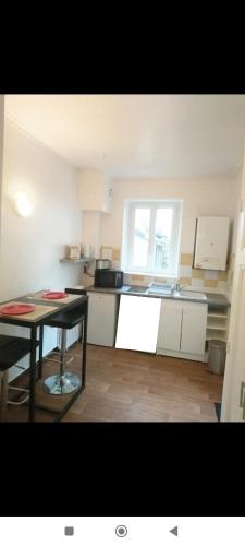 a kitchen with a table and a small kitchen with a window at Lesage in Lorient
