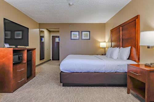 a hotel room with a bed and a flat screen tv at Comfort Inn Ottawa Kansas in Ottawa