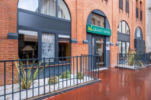 a building with a fence in front of it at Quality Hotel Toulouse Centre in Toulouse
