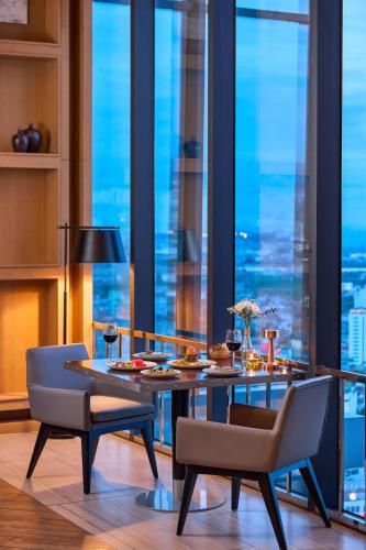 a dining room with a table and chairs in front of a window at Meliá Vinpearl Thanh Hoa in Thanh Hóa