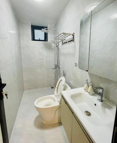 a white bathroom with a toilet and a sink at Mẹ Nhím homestay in Chung Cap