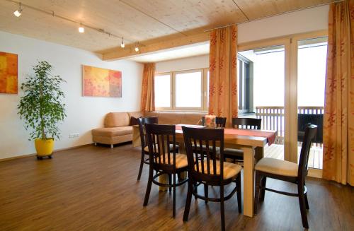 ein Esszimmer mit einem Tisch, Stühlen und einem Sofa in der Unterkunft Apart Marienberg in Lermoos