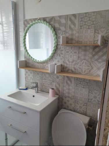 a bathroom with a toilet and a sink and a mirror at La Tuilerie Lixy Brannay in Brannay