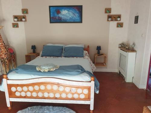 a bedroom with a bed with blue pillows at La Tuilerie Lixy Brannay in Brannay