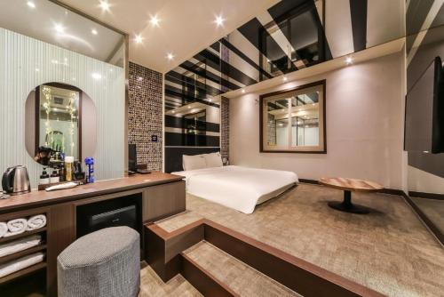 a bedroom with a bed and a desk and a mirror at Ulsan Seongnam Hotel Mar in Ulsan