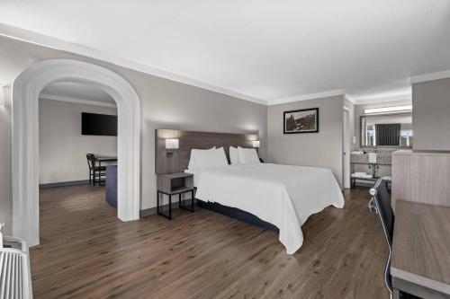 a bedroom with a large white bed and a desk at Quality Inn & Suites Ocala I-75 in Ocala