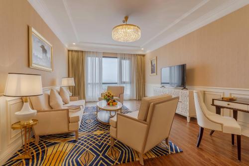 a hotel room with a living area with furniture and a television at Meliá Vinpearl Phu Ly in Phủ Lý