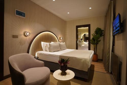 a hotel room with a bed and a chair at Gülten Hanım Konağı in Gaziantep
