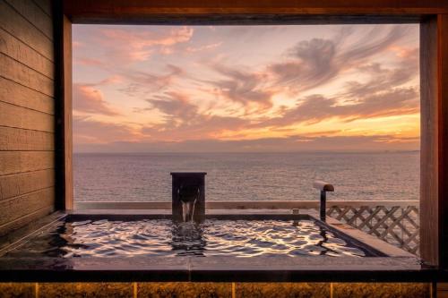 a view of the ocean from a hot tub on a house at Inatori Tokai Hotel Yuen in Higashiizu