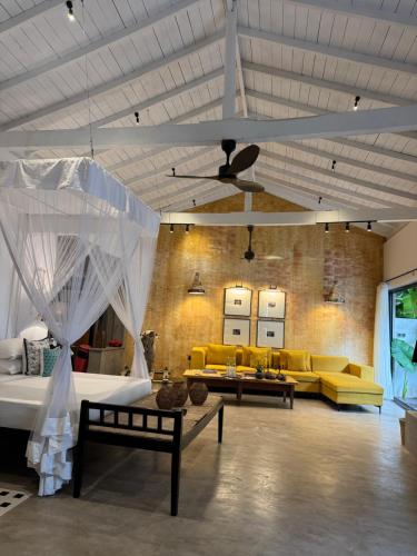 a living room with yellow couches and a ceiling at Palace Bope Galle in Galle