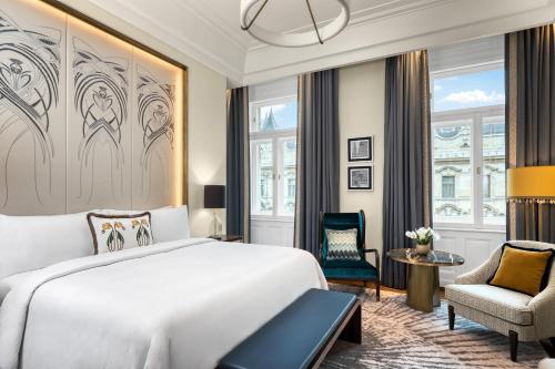 a bedroom with a bed and a chair at Matild Palace, a Luxury Collection Hotel in Budapest