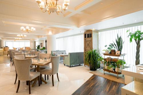 a restaurant with tables and chairs and a chandelier at Peninsula Grand in Mumbai