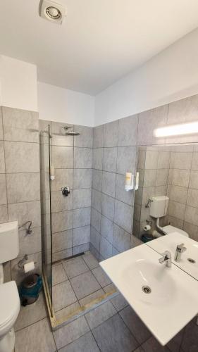 a bathroom with a shower and a sink and a toilet at Hotel Imperial Timisoara by JR in Timişoara