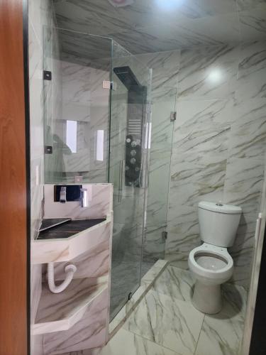 a bathroom with a toilet and a glass shower at departamento para Hospedaje en zacatlan in Zacatlán