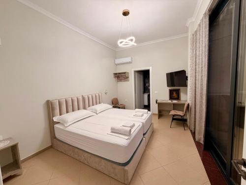 a bedroom with a bed and a desk and a television at Berat GuestHouse "AAA" in Berat