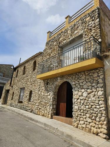 a stone building with a balcony on top of it at Spacious House in Can Trabal in Can Trabal