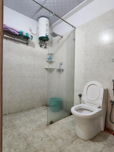 a bathroom with a toilet and a shower stall at Shivara Homes in Jaipur