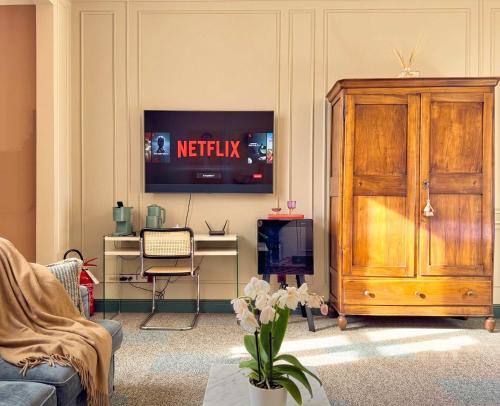 ein Wohnzimmer mit einem Fernseher an der Wand in der Unterkunft Homeby, Cinisca Suites in Bologna