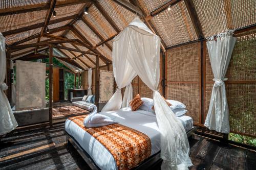 a bedroom with a bed with a mosquito net at Oak House Sidemen in Sidemen